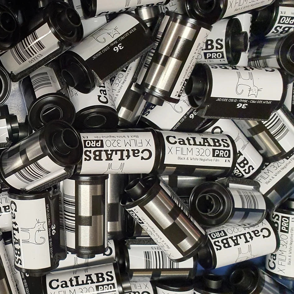 Collection of 35mm film cans with visible branding on a textured surface