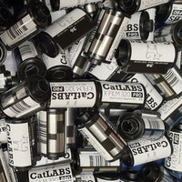 Collection of 35mm film cans with visible branding on a textured surface