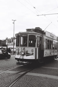 Vintage tram on a street with advertisements and 'Carmo' branding.