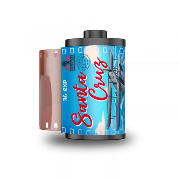 A roll of Santa Cruz 36 exp film with a blue and red label featuring an airplane illustration, shown alongside a partially exposed pink film strip on a white background.
