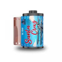 A roll of Santa Cruz 36 exp film with a blue and red label featuring an airplane illustration, shown alongside a partially exposed pink film strip on a white background.