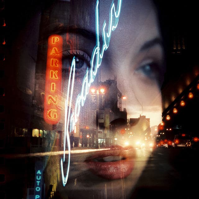 Neon signs and cityscape with a person's face overlay