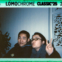 Two people posing for a photo with LomoChrome Classic '25 film effect overlay.