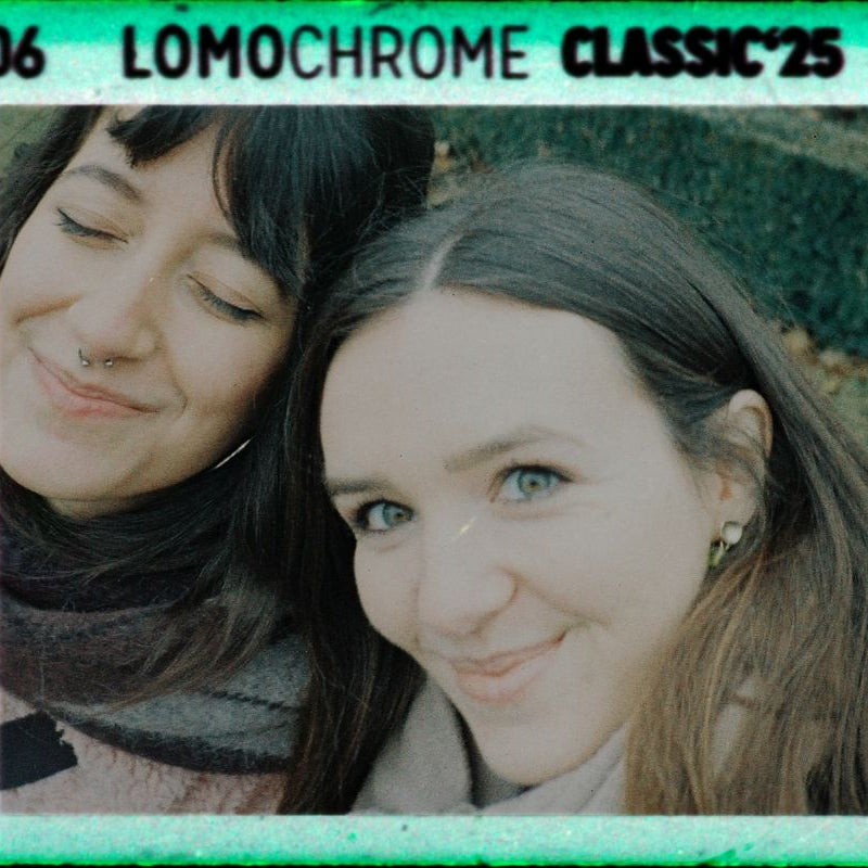 Two women posing together with a LomoChrome Classic '25 filter overlay.