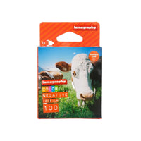 Lomography film packaging with a cow on a grassy field