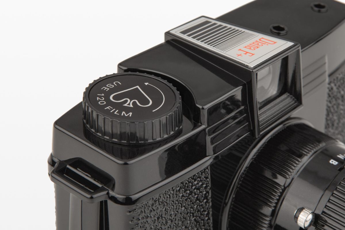 Close-up of a camera lens with a focus indicator light on a black background