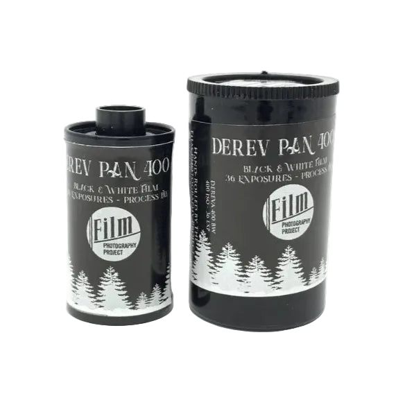 Two black cylindrical film canisters with white printed text and pine tree graphics, labeled Deriv Pan 400 Black & White Film, on a plain white background.