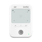 A white Godox handheld wireless flash controller with a gray LCD screen, directional buttons, and a central power button, shown on a solid white background.