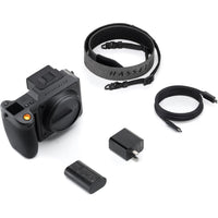 Camera kit with Hasselblad camera body, strap, battery, charger, and cable on a white background