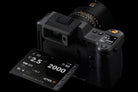 Camera lens and digital display with exposure settings on a black background