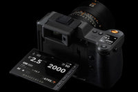 Camera lens and digital display with exposure settings on a black background