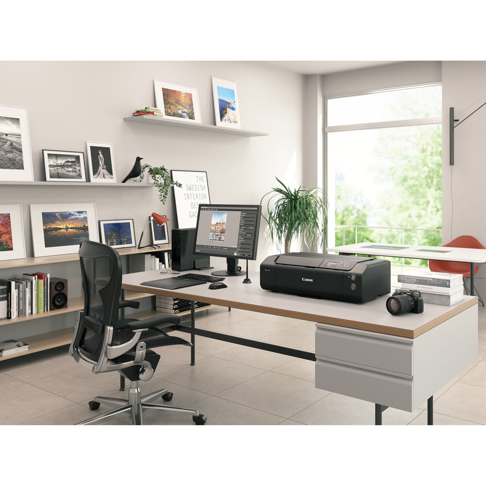 Modern office setup with a desk, chair, computer, printer, and camera.