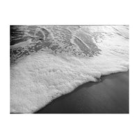Black and white photo of ocean waves crashing onto a beach