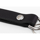 Close-up of a black textured leather keychain strap with a silver metal snap button engraved with 'long life' and silver key rings on a white background.