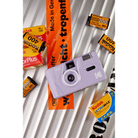 Purple camera with Kodak film packaging on a white background
