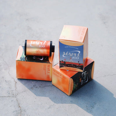 Two cartons with 'Maple 100' branding on a concrete surface