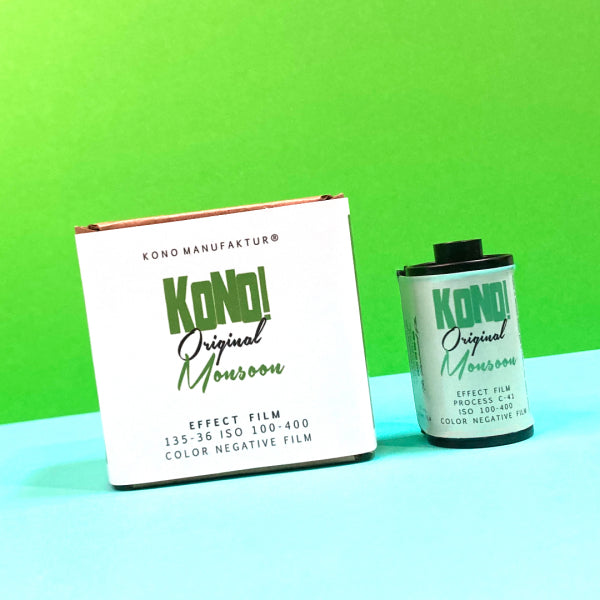 A box and a canister of Kodo Original Monroon effect film photographed on a bright green and light blue background.