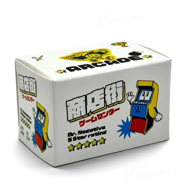 A white rectangular product box with Japanese text and colorful arcade machine illustrations, photographed on a plain white background.