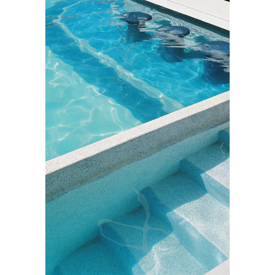 Close-up of a swimming pool with clear blue water and white coping.
