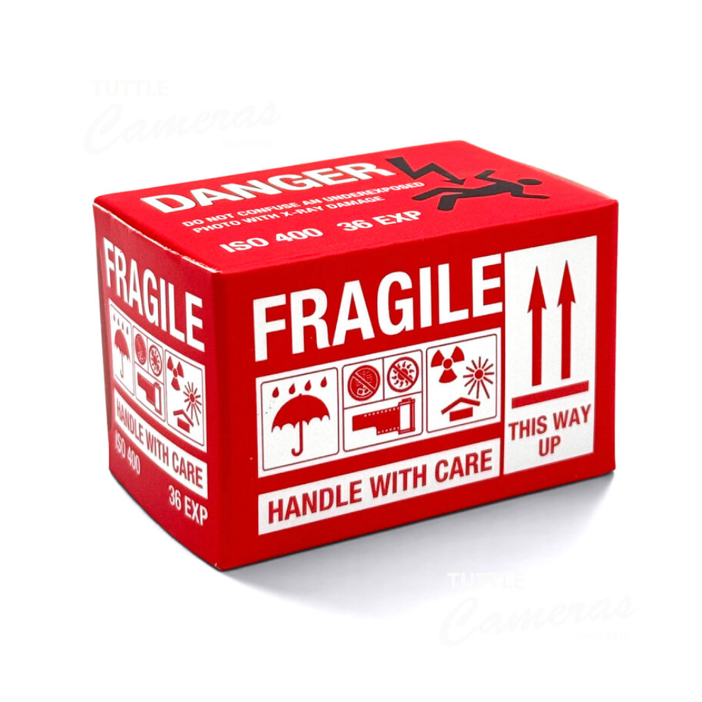 A red and white fragile shipping box with handling symbols and text, photographed on a clean white background.