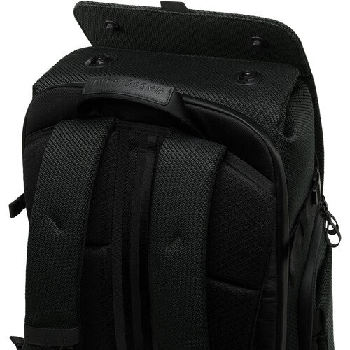 Close-up of a black backpack with visible branding on a white background