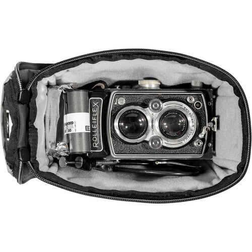 Vintage Rolleiflex camera inside a black leather case on a white background