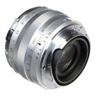 Close-up of a camera lens with metallic finish on a white background
