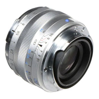 Close-up of a camera lens with metallic finish on a white background