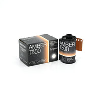 A photograph of a 35mm color negative film roll and its packaging box, labeled 'AMBER T800'.