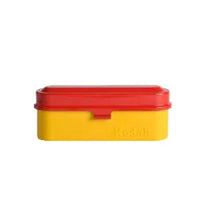 A portable steel film case with a red top and yellow bottom, branded with the name 'Kodak'.