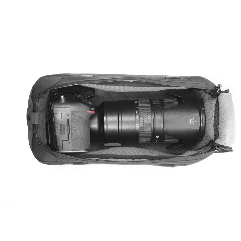 Camera with a large lens inside a black carrying case on a white background