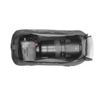 Camera with a large lens inside a black carrying case on a white background