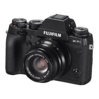 Fujifilm X-Ti mirrorless camera body with a black lens, shown from a three-quarter angle on a white background.